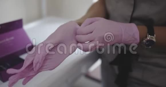 美容师戴上粉红色手套拍摄于12比特色深的电影院视频的预览图