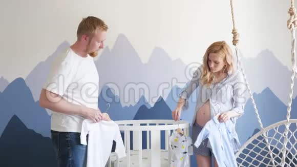 年轻的家庭在山上为未出生的孩子收集婴儿床孕妇及其丈夫视频的预览图
