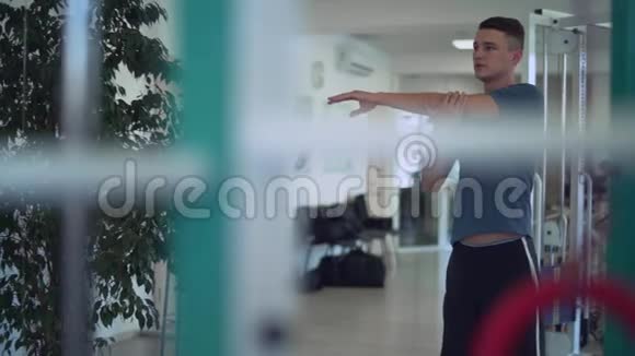 帅哥在健身房训练前揉捏他的手在健身房里的人健康的生活方式视频的预览图
