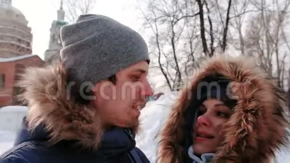 一对男女在视频连接上交谈亲吻和行走在冬天的城市公园在下雪的日子里下雪了视频的预览图