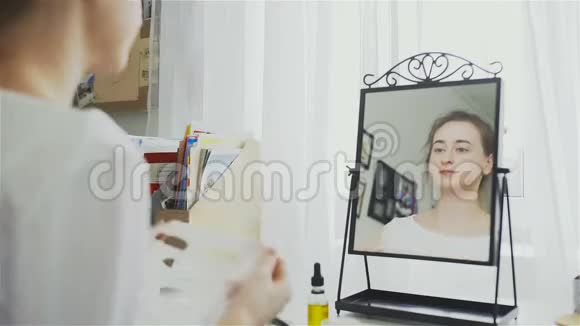 女人在脸上戴着日本化妆面具照镜子视频的预览图
