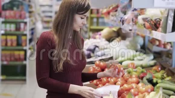 小女孩在超市的杂货店买蔬菜然后放进塑料袋里视频的预览图