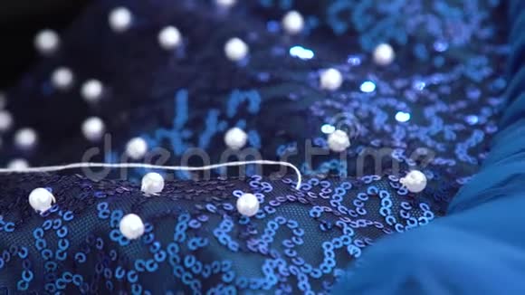贴身裁缝用手把珠子缝到蓝色布上视频的预览图
