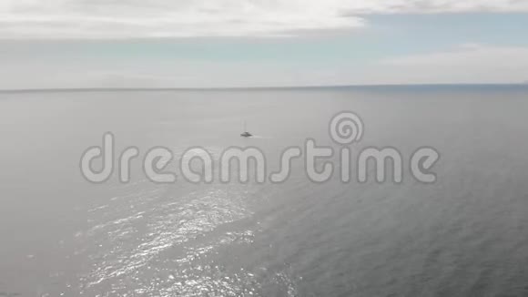 空中射击一艘孤独的帆船在蓝色的海水中航行对着蓝天的概念视频的预览图