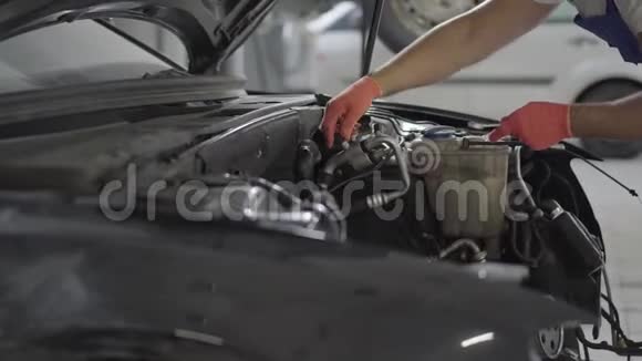 在汽车发动机附近工作的机械师用手指紧握细节戴手套的汽车师傅视频的预览图