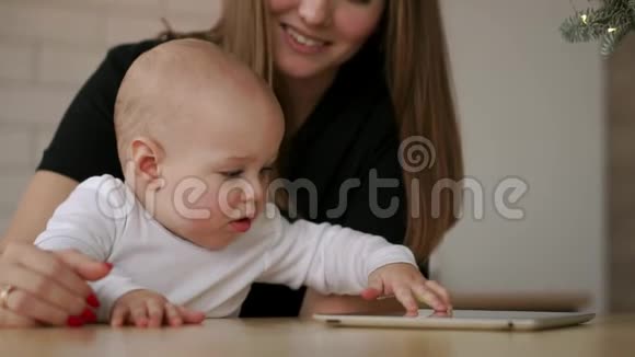 年轻的白种人母亲用平板电脑和她的小儿子慢运动120fps母亲给孩子看数字平板视频的预览图