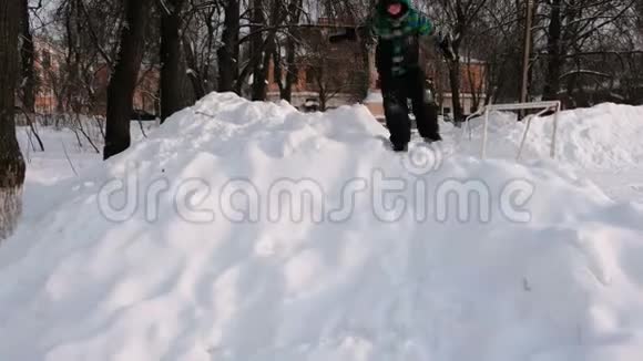 男孩在雪地里玩耍从雪山倒飞而去视频的预览图