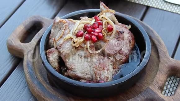 美味的格鲁吉亚美食在泥锅里煎肉配上洋葱和石榴籽视频的预览图