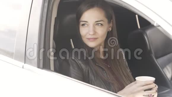 年轻美丽的白种人女性坐在车里手里拿着咖啡视频的预览图