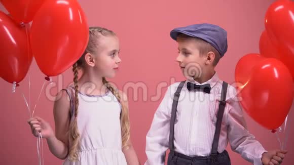 男孩和女孩拿着红心气球互相看着初恋视频的预览图