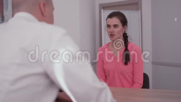 他的办公室里正和女孩说话心理治疗在医生的接待处接待室的女病人视频的预览图