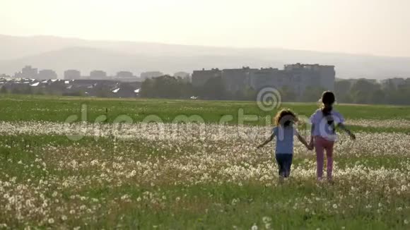 暑假姐妹们奔跑在蒲公英的田野里欢乐幸运的童年回到了家幸福健康爱视频的预览图