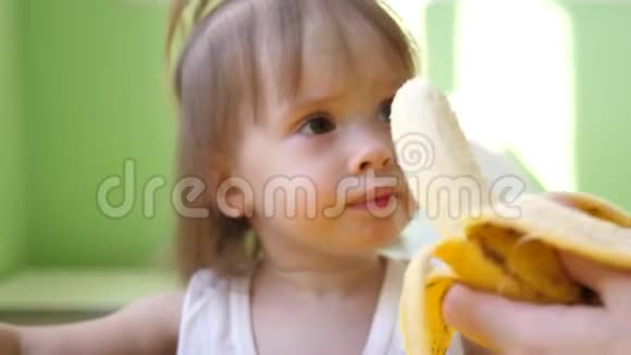 妈妈在厨房的桌子旁喂小香蕉为幼儿补充可爱的零食小子视频的预览图