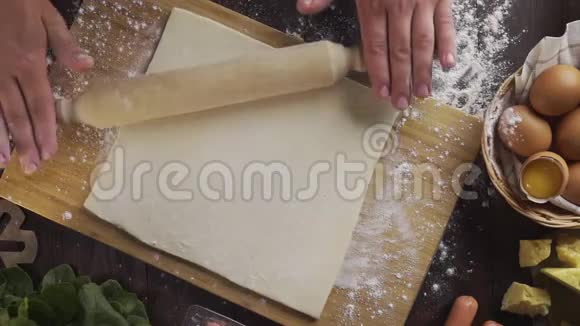 平躺镜头厨师用擀面杖在厨房的桌子上擀面桌面上擀面杖视频的预览图