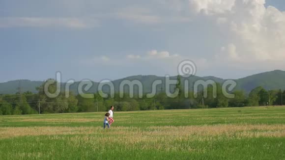 两个快乐的姐妹在蒲公英的田野里玩耍快乐的小女孩玩得很开心在城市附近的草地上奔跑概念视频的预览图