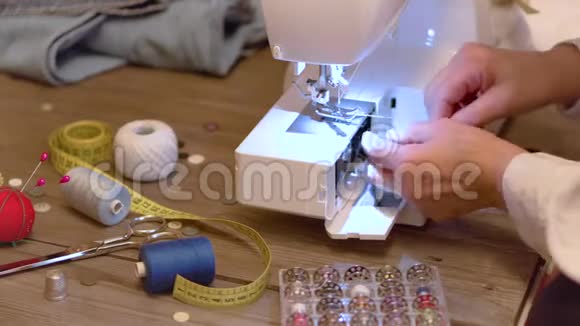 高级裁缝手准备电动缝纫机的线视频的预览图
