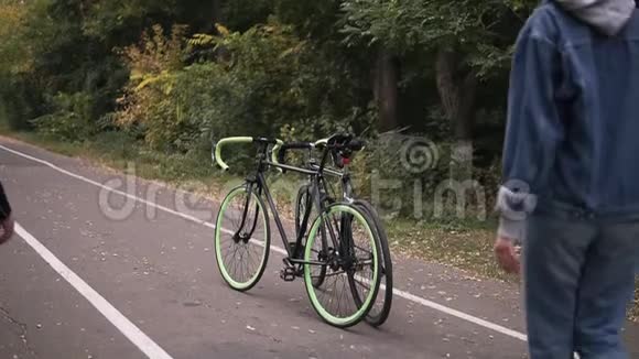 一对夫妇坐在自行车上清晨骑自行车两个人在秋天的城市公园男人和女人骑自行车视频的预览图