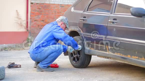 男性汽车修理工用扳手固定汽车车轮视频的预览图