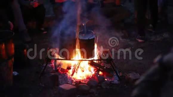 人们晚上用篝火在金属桶里加热水视频的预览图