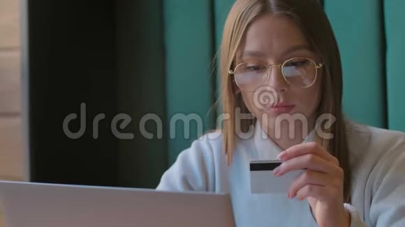 年轻女性买单网购插入信用卡号码有魅力的女人在网上购物视频的预览图
