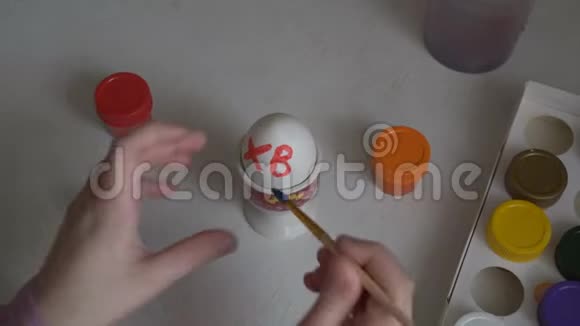 孩子画复活节彩蛋并用画笔在上面画符号快关门从上面看到的4K25fps视频的预览图