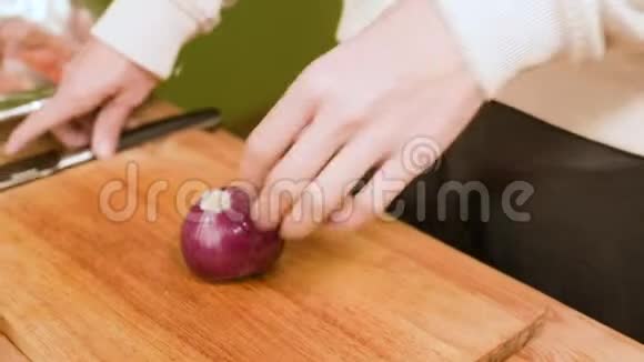 贴身女人她的手在厨房的木板上切洋葱视频的预览图