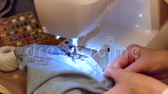 缝制牛仔牛仔裤用缝纫机修理牛仔裤慢动作剪辑视频的预览图