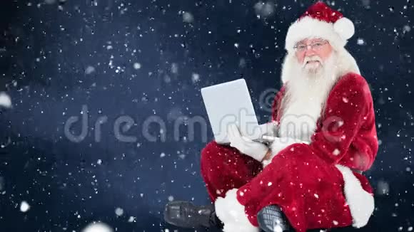 圣诞老人坐在他的笔记本电脑前加上下雪视频的预览图