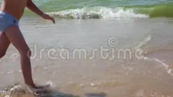 孩子在海滩上玩孩子在海浪中跳跃有孩子的家庭的海上假期小男孩在热带奔跑视频的预览图