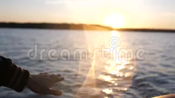 在海上日落的时候把雄性的手收起来人类大自然中背景海水上的太阳射线夏日时光眩目视频的预览图