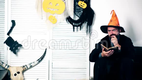 一个穿着女巫西装人看书和手势万圣节派对和庆祝理念穿着服装的家庭视频的预览图
