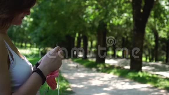 小女孩在公园里的长椅上编织视频的预览图