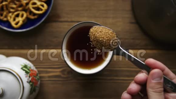 把糖从勺子里倒入一杯茶中视频的预览图