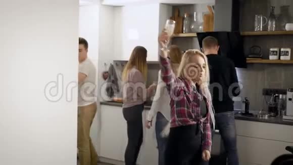 两位金发女郎正在大学教室的一个聚会上厨房里跳舞她们和朋友一起喝香槟视频的预览图