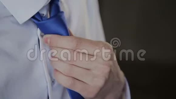 一个男人调整他的蓝色领带视频的预览图