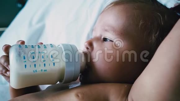 婴儿奶瓶喂养接近慢动作一个缓慢的动作关闭了一个9个月大的婴儿从瓶子里喂食视频的预览图