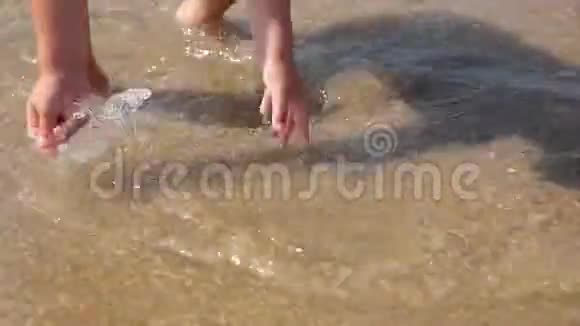 男孩把手指伸向海边的沙滩有孩子的家庭的海上假期小男孩在热带海滩上奔跑视频的预览图