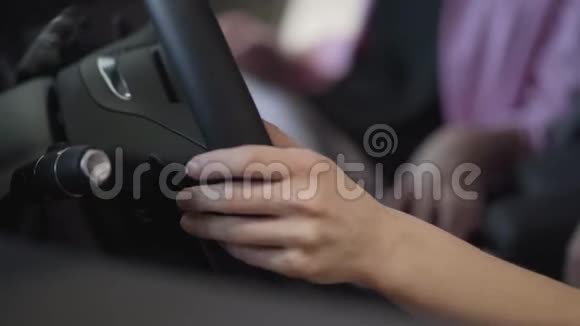 女人把手放在大方向盘上现代女孩在车展上选择汽车购买概念视频的预览图