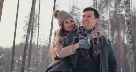 年轻美丽的夫妇在雪的冬天在户外玩耍视频的预览图