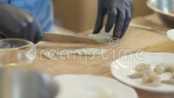 厨师用尖刀切菜在木板上放绿色新鲜黄瓜在大盘子里准备沙拉视频的预览图