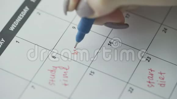 女人用红笔在日历上写字视频的预览图