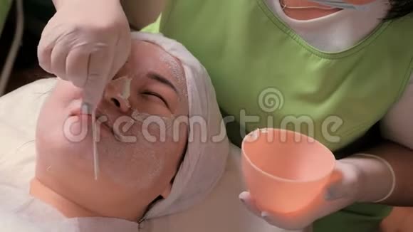 戴手套的美容师用工具清洁女性的脸美容中皮肤复健和清洁的过程视频的预览图