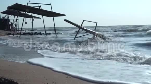 老旧破损被破坏的亭台雨篷被海水淹没在沙滩上波涛汹涌的大海倾泻在屋顶视频的预览图