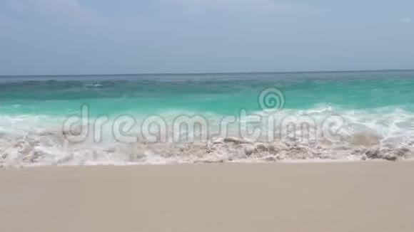 碧蓝的天际线景观上沙滩上的海波绿松石水海浪拍打着沙滩的地平线视频的预览图
