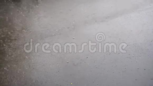 强烈的雨水滴落在沥青上视频的预览图