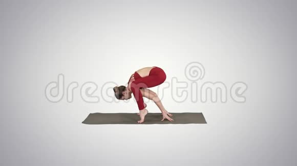 美丽的女人练习倒立瑜伽如提蒂巴哈萨纳萤火虫姿势在梯度背景视频的预览图