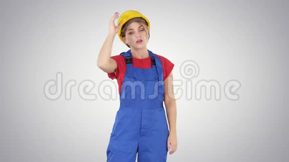工作日结束建筑工人妇女在梯度背景下脱帽视频的预览图