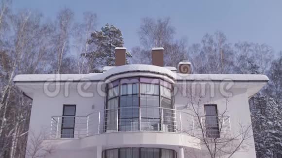 外观美丽的白色现代设计家居在冬天的雪树和蓝色的晴空背景库存录像二视频的预览图