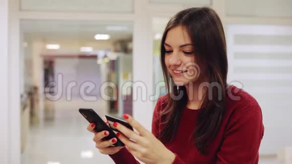 女人用信用卡在智能手机上从网上购买商品视频的预览图