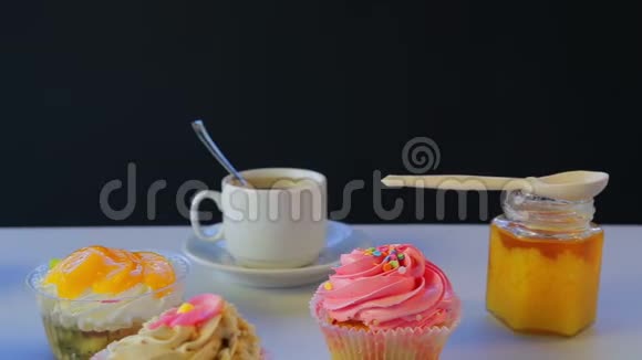 灰色的桌子上放着白色杯子里的茶和蛋糕视频的预览图